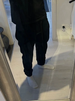 Essentials - Snygga svarta essentials sweatpants med avslappnad passform. Perfekta för chill dagar eller när du vill vara bekväm. Byxorna har elastisk midja och raka ben. Tillverkade i mjukt material som känns skönt mot huden.