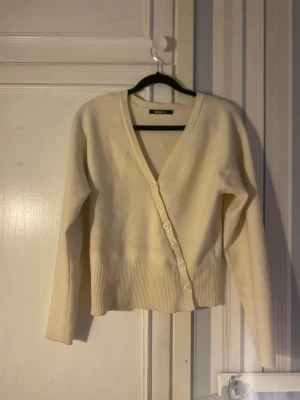 Krämvit kofta från Gina Tricot - Krämvit kofta från Gina Tricot med v-ringning och knäppning framtill🤍Kan skicka bild på, priset kan diskuteras💞