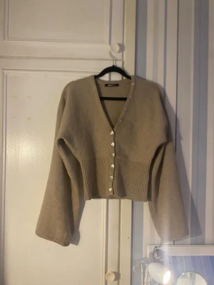 Beige kofta från Gina Tricot - Beige kofta med v-ringning och pärlemorknappar från Gina tricot🤍 Kan skicka bild på💞Priset kan diskuteras 