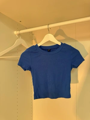 Blå croppad topp från SHEIN - Snygg blå croppad topp från SHEIN med ribbad struktur och korta ärmar. Perfekt till jeans eller kjol för en trendig look. Enkel och stilren design som är lätt att matcha med olika outfits.💙