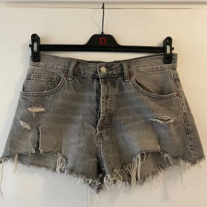 Jeansshorts  - Gråa jeansshorts med slitningar från Zara. Jättesnygga och populära! Lappen i bak där ”zara märket” brukar vara har jag tagit bort för en mer clean look.