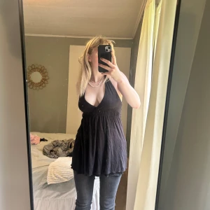 Svart omlott tunika med knyt - Säljer en svart tunika med omlott och djup v-ringning från gina!