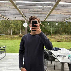 Svart långärmad tröja Maglia Studio - En stilren svart långärmad tröja från Maglia Studio. Tröjan har rund halsringning och är tillverkad i mjuk bomull, perfekt för lager-på-lager. Enkel och clean design som funkar till det mesta. Nypris ca 1299