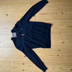 Mörkblå merinoullströja från Morris - OBS! Tröjan har krymt och stämmer inte med Morris storleksguide, tröjan är ca 5-15 cm kortare i alla mått. Passar perfekt till nån som vill han en stilren tröja och är ca 155-160 cm lång.