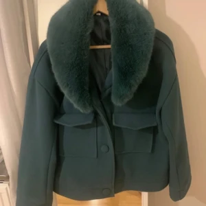 Liknande meotine jacka  - Snygg mörkgrön jacka med oversized pälskrage och stora fickor framtill.  Jag köpte den begagnade så jag vet inte märket💕