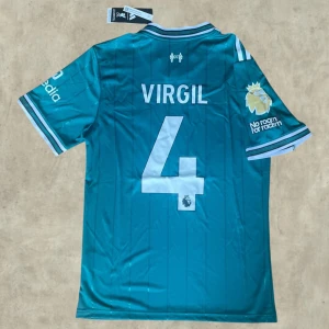 Liverpool Third kit 25/26 ”VIRGIL #4” - Liverpool Tredje kit med VIRGIL #4 på ryggen. Fint skick och det guldiga EPL märket finns även på, Storlek M men passar även S  Kom gärna med bud och frågor, kan även sänka vid snabb affär 🤝