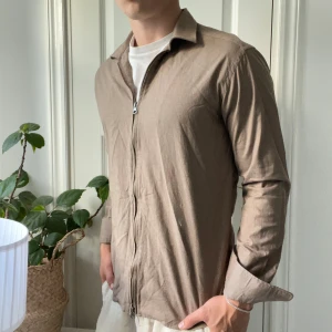 John Henric full zip M  - John Henric full zip M, i tjockt skjort material. Inga defekter, väldigt skön och hög kvalité. Modellen är 180,75 kg och bär M.