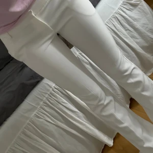 Vita bootcut kostymbyxor - Snygga vita kostymbyxor med bootcut-snitt och midwaist. Byxorna har hällor för bälte och klassiska fickor fram. Perfekta för en clean och fräsch look. Materialet känns mjukt och följsamt.