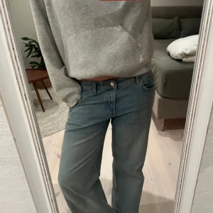 Blå low wide jeans från Zara - Säljer ett par ljusblå lågmidjade jeans från Zara med rak och wide passform. Slutsålda på Zaras hemsida. Perfekta för dig som gillar en avslappnad och trendig look. Har sytt upp dem längst ner för att de var för långa. Jag är 170 cm lång.