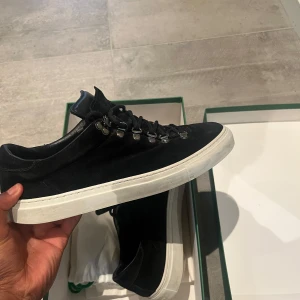 Svarta mockasneakers från Diemme - Snygga svarta sneakers från Diemme i mocka med vit platt sula. Skorna har metallhakar för snörningen och en stilren, minimalistisk look. Perfekta för dig som gillar italiensk design och vill ha något som sticker ut lite extra.