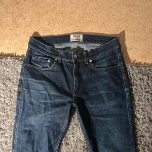 Acne studios vintage jeans - Säljer ett par snygga Vintage Acne Studios Ace STR jeans i mörkblå tvätt. Storlek 31/34 men skulle säga de sitter som 31/32. Modellen är slim med raka ben, bra skick förutom att man ser lite användning, men inte när de används. Inga defekter eller så. Säljs för 400kr nypris runt 1600kr. Priset går att diskutera. Kontakta mig om du har frågor👍🤗