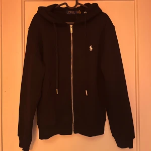 Svart Ralph Lauren zip hoodie  - Säljer min svarta Ralph lauren zip hoodie. En stilren hoodie i storlek M. Vid fler frågor kom privat 