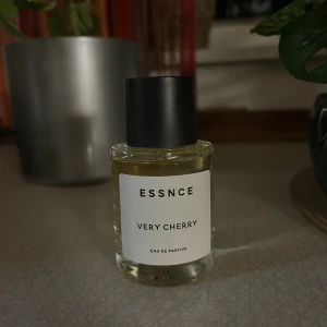 ESSNCE Very Cherry Eau de Parfum - Parfymflaska med minimalistisk design från ESSNCE. Doften Very Cherry har tydliga inslag av körsbär, mandel, vanilj och kanel. Flaskan är genomskinlig med svart lock och vit etikett. Perfekt för dig som gillar fruktiga och söta dofter.