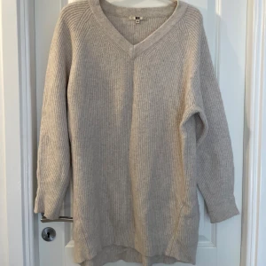 Uniqlo Beige stickad tröja  - Mysig beige stickad tröja från Uniqlo i storlek L. Tröjan har v-ringning, lång ärm och ribbad struktur. Perfekt för lager-på-lager och chill dagar. Enkel och stilren design som funkar till det mesta.