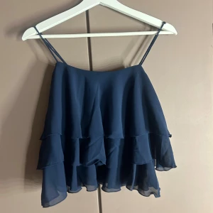 Mörkblå volangtop från Gina Tricot - Oanvänd volang topp från Gina! Toppen går inte längre att köpa, har råkat riva av lappen på ena sidan😅