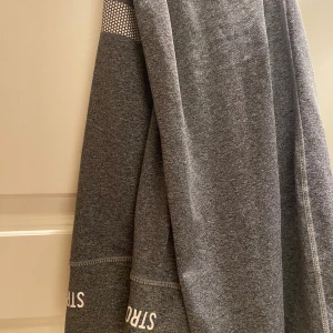 Grå leggings från Stronger - Mörkgrå leggings från Stronger med vit logga på benet. 💕💕💕