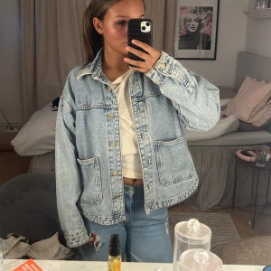 Oversized ljusblå jeansjacka - Säljer en oversized ljusblå jeansjacka med klassisk krage och stora framfickor. Jackan har bara andvänts några få tillfällen i somras 