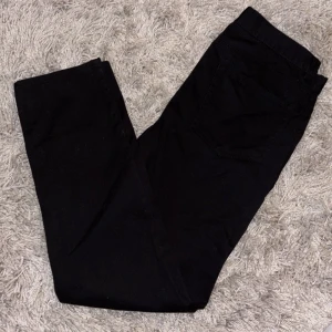 Svarta slim fit byxor från H&M - Svarta slim fit byxor från H&M i storlek 32/32. Snygg, smal passform med klassiska fickor och knappstängning. Tillverkade i mjuk bomull med lite elastan för extra komfort och rörelsefrihet. Perfekta för en clean och stilren look. Hör av er vid fler bilder! Pris kan diskuteras.