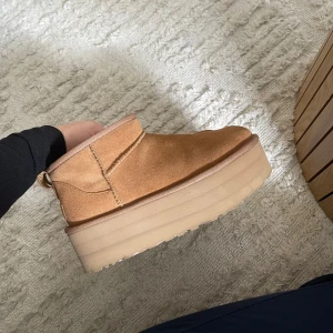 UGG boots med plattform, beige mocka - Säljer mina ugg inköpta i december förra året. Kvitto finns!! Köpta för 2250kr + frakt från deras egna hemsida. Använda 2 gånger! Kan behöva sig en lätt tvätt uppe på ena foten efter att jag fällt ihop barnvagnen. Storlek 37 men passar en 38 när fluffet format sig, rekommenderar inte att köpa förrens man är säker på sin storlek i just ugg. Älskar dom men då jag har en 1 åring att jaga är inte dessa så ultimata..😅💕   #ugg #uggs #platform #höst #vinter