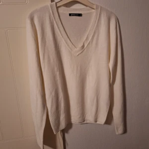 Vit v-ringad tröja Gina Tricot - Vit v-ringad tröja från Gina Tricot i storlek S. Tröjan är stickad med ribbade muddar och har en liten broderad krona på bröstet. Super mjukt material🤩