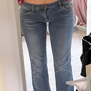 Replay bootcut jeans med broderi - Snygga blå jeans från Plastic med bootcut passform och klassisk femficksdesign. Baksidan har coolt brunt broderi på fickorna. Jeansen har låg midja och är gjorda i mjukt denim-material som sitter skönt. Perfekta för dig som gillar retrovibbar och stilren look.