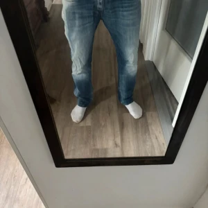 Replay jeans i ljusblå - Säljer ett par snygga Replay jeans i ljusblå tvätt med slitningar och klassiska bakfickor. Jeansen har normal passform och raka ben, tillverkade i bomull. Perfekta för dig som gillar en avslappnad stil.