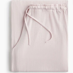 Pyjamas byxor  - Supermjuka ljusrosa pyjamas/ mjukisbyxor med ribbat mönste. Byxorna har en relaxed fit och är perfekta för chill dagar hemma. Materialet är bomullsmix som känns skönt mot huden. Aldrig använda ! Men stora i storleken då dom är väldigt stretchiga vid midjan 
