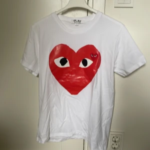 Vit Comme des Garçons Play t-shirt - Säljer en vit t-shirt från Comme des Garçons Play i storlek M, men passar även S. Hör av dig vid funderingar!