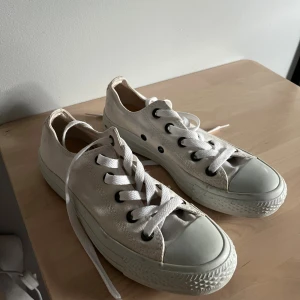 Vita låga Converse All Star sneakers - Klassiska vita Converse All Star sneakers i låg modell. Skorna har vita snören, svarta metalldetaljer och gummitå. Knappt använda och i mycket bra skick.