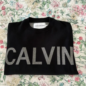  Calvin Klein Sweatshirt / Tröja - Svart sweatshirt från Calvin Klein Jeans.               Grå logga framtill. Klassisk rund halsringning och enkel, stilren design som passar perfekt till jeans. Mjuk bomullskänsla och riktigt snygg. Storlek S men skulle kunna passa M också! 