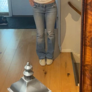 Bootcut jeans  - Säljer ett par snygga ljusblå bootcut jeans från ONLY. Jeansen har klassisk femficksdesign, låg midja och är tillverkade i mjuk denim. Midjemåttet är 33cm och Innerbensmåttet är 75cm