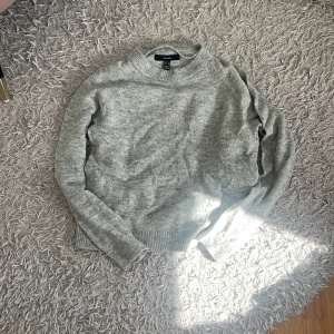 Grå stickad tröja  - Mysig grå stickad tröja från vero moda med rund halsringning och ribbade muddar vid ärmslut och nederkant. Perfekt för lager-på-lager och chill dagar. Enkel och stilren design som funkar till det mesta.
