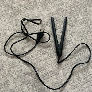 Beautine mini Plattång - Smidig och kompakt plattång från Beautine, perfekt för både resor och vardagsbruk. Svart design, lätt att använda och med lång sladd. Ser ut att vara i mycket gott skick utan synligt slitage eller defekter. Fungerar utmärkt för att snabbt styla håret.