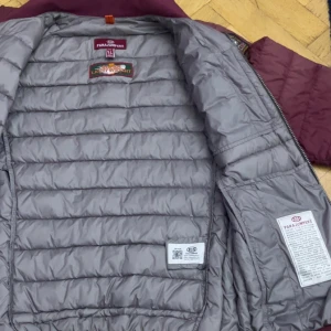 Vinröd dunjacka från Parajumpers - Säljer en vinröd dunjacka från Parajumpers i storlek  s. Jackan har quiltad design, ståkrage och dragkedja framtill. Fodret är grått och jackan har två sidofickor med dragkedja samt patch på ärmen. Perfekt för kyliga dagar.