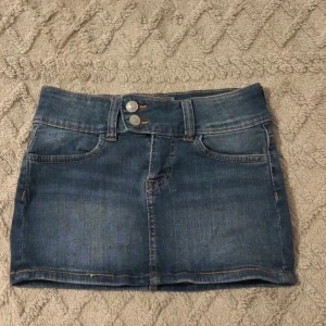 Blå jeanskjol  - Säljer en blå jeanskjol H&M i storlek 32. Aldrig använd. Ljuset får det o se ut som att det är fläckar vilket de inte är. Inga defekter eller fläckar. För fler bilder skriv privat!