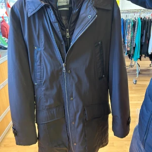 Mörkbrun dunjacka från Moncler - Säljer en mörkbrun dunjacka från Moncler med lång ärm, flera fickor och snygga detaljer som dragkedja och knappar. Jackan har en klassisk parkamodell med hög krage och quiltad insida. Perfekt för kalla dagar och riktigt stilren. Detta är en vintage jacka från tidig 2000 talet