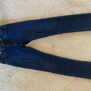 Jack & Jones Slim Glenn jeans blå 29/30 - Mörkblå jeans från Jack & Jones i modellen Slim Glenn. Snygg slim fit med klassiska fem fickor, kontrastsömmar och läderpatch bak. Tillverkade i mjukt bomullsjeansmaterial som sitter skönt hela dagen.