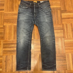 Blåa jeans jack & jones - Ett par snygga jack & jones jeans med skön wash. Passform är slim/rak. Storlek w33 l30 men jag gissar på att de är lite mindre i midjan. Inga defekter förutom ett hål i vänster ficka. Inget som syns! Hör av er om ni undrar något.