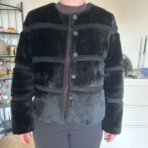 Mysig och varm fuskpälsjacka - En superfin och mysig vinterjacka i fuskpäls från Neo Noir. Den är tjock och varm. Modellen heter Kahla Faux Fur Jacket. Den är mjuk och mysig som teddy.