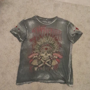 Grå Affliction Dödskalle Tshirt - Har använts ganska mycket och har ett par små hål här och där och några delar på botten är lite rivna