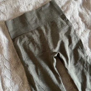 seamless leggings - Säljer ett par gröna träningstights med hög midja och scrunch-detalj bak. De har ribbad linning och struktur längs sidorna och bak för extra snygg passform. Perfekta för gymmet eller annan sport.