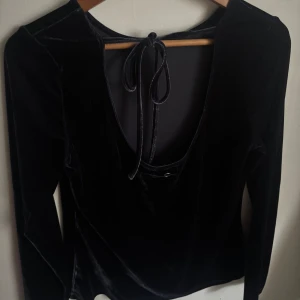 Blå sammets topp med öppen rygg - Snygg blå långärmad topp i mjuk sammet med  öppen rygg och knytband i nacken💙