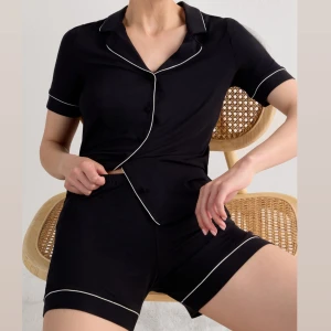 Svarta pyjamas intimissimi med vit kant  - ”Tröja med kort ärm och öppning fram i modal” och ”Shorts i modal med kontrasterande passpoal” från intimissimi. Säljs endast i set och inte en och en. Original pris: 980kr