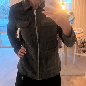 Grön manchester overshirt från Pieces strl S  - Snygg grön overshirt från Pieces i mjuk manchester med raka linjer och klassisk krage. Jackan har två stora bröstfickor med lock, hel dragkedja framtill och långärmad passform. Perfekt för lager-på-lager och chill stil.