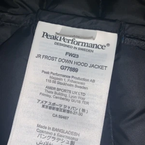 Svart dunjacka Peak Performance  - Säljer en svart dunjacka från Peak Performance, modell JR Frost Down Hood Jacket. Jackan har quiltad design, dragkedja framtill och huva. Perfekt för kalla dagar och riktigt snygg passform. Klassisk logga på bröstet och ärmen.