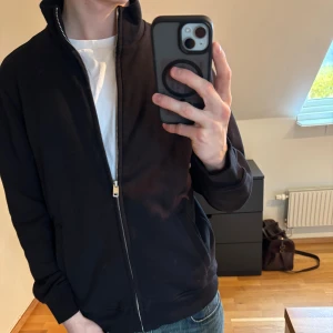 Svart zip-tröja – Mango MNG - Snygg och stilren zip-tröja i klassisk svart färg – perfekt till både vardag och jobb! Dragkedja hela vägen Använd endast 1–2 gånger – i nyskick Storlek S, men passar även M (jag är 181 cm och den sitter bra)                                                    Nypris: 749 kr