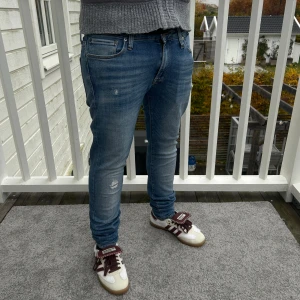 Blåa jack & jones jeans W30/L34 - Ett par sjukt snygga jeans med revor från jack & jones. Bra skick 8,5/10! Storlek är W30/L34! Modell skinny Liam!😀