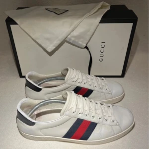  Gucci ace skor  - Tja säljer dessa Gucci skor skor i storlek 42/43. Bra skick men finns tecken på användning med lite crease här och där men inget som syns vid användning. Priset är ej hugget i sten och ingen box men dust bag medföljer vid köp!