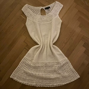 Söt virkad klänning - Supersöt benvit virkad klänning från Mango. Jättefint skick. Vacker ringning och knapp där bak. Lår-längd.