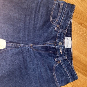 Mörkblå lowwaist bootcut jeans från Abrand - Snygga mörkblå jeans från Abrand med klassisk femficksdesign och kontrastsömmar. Modellen har rak passform och normal midja, tillverkade i slitstarkt denimtyg. Perfekta för dig som gillar stilrena och tidlösa jeans. Dom är så fett snygga men för små för mig i midjan skulle säga att dessa är en 34 finns endast en enda defekt längst ner som man inte lägger märke till att till.❤️ behövs bilder på är det att komma privat 💋🫶🏻